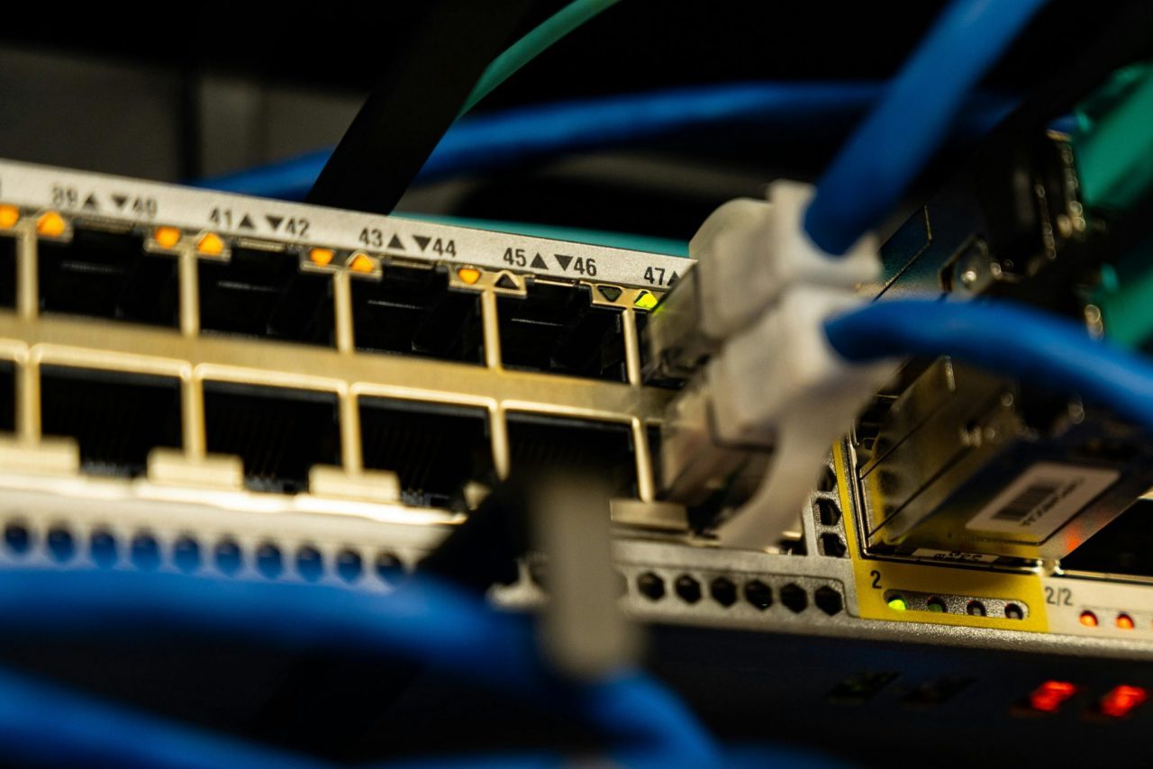 Close-up image of ethernet cables plugged into a network switch, showcasing IT infrastructure.